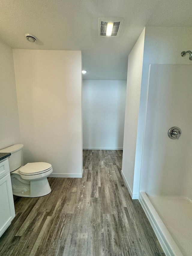 bathroom with hardwood / wood-style flooring, toilet, and vanity