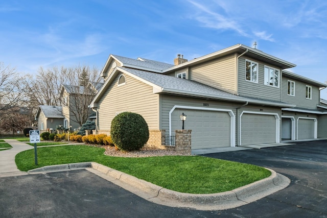 view of side of home with a garage and a lawn