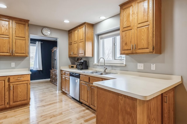kitchen with brown cabinets, dishwasher, a healthy amount of sunlight, and a sink