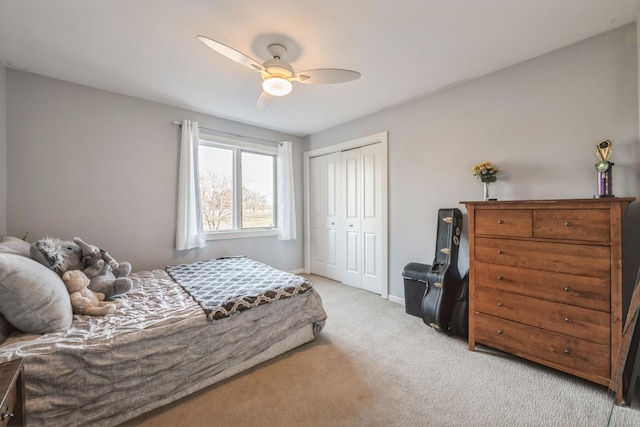 bedroom with ceiling fan, baseboards, a closet, and light colored carpet
