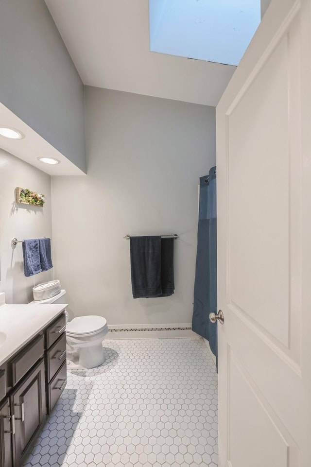 full bath featuring toilet, a shower with curtain, vanity, and baseboards