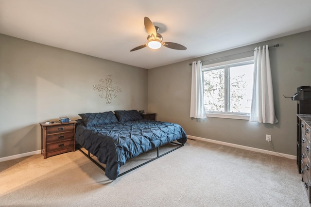 bedroom featuring light carpet, baseboards, and ceiling fan
