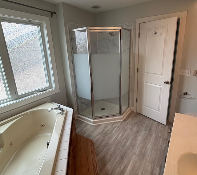 bathroom with vanity, wood finished floors, a whirlpool tub, and a shower stall