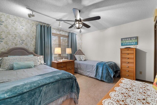 carpeted bedroom featuring a textured ceiling, ceiling fan, and rail lighting