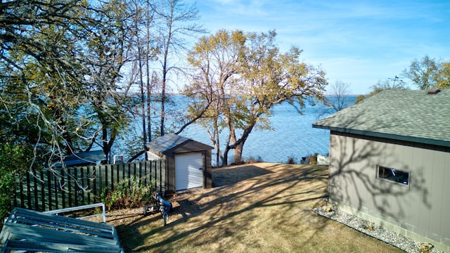 view of yard with a water view and a storage shed