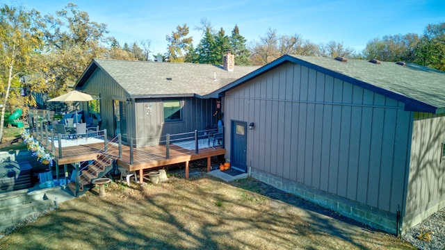 back of house with a deck and a yard