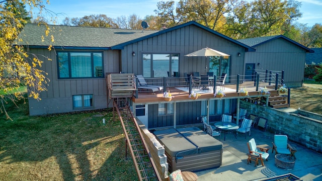 rear view of house with a patio area, a yard, a fire pit, and a wooden deck