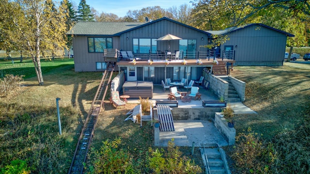 rear view of house featuring an outdoor living space with a fire pit, a hot tub, a yard, and a patio