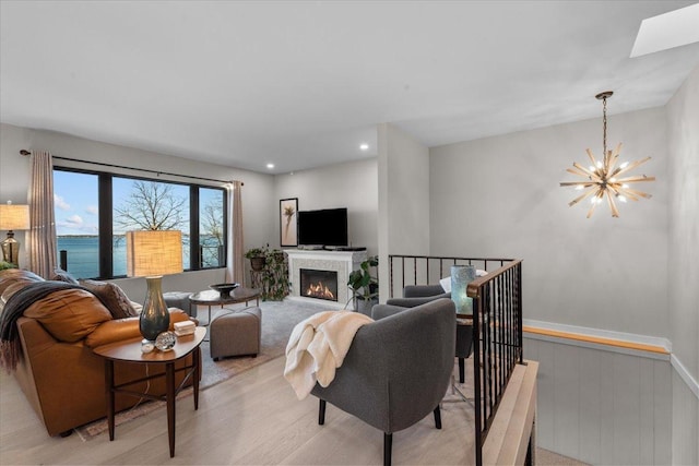 living room featuring a skylight, a chandelier, and a water view