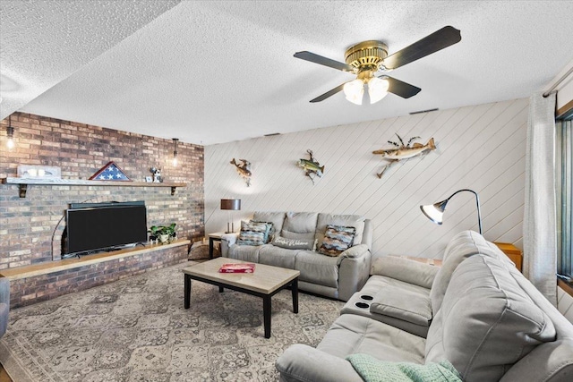 living room with ceiling fan, a textured ceiling, and wooden walls