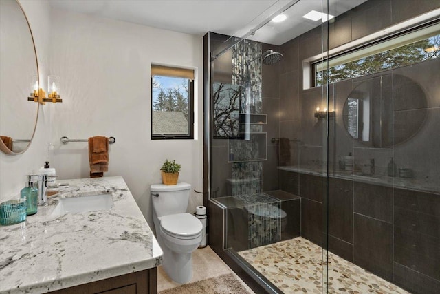 full bath featuring a chandelier, vanity, toilet, and a stall shower