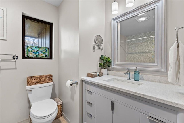 bathroom with baseboards, toilet, and vanity