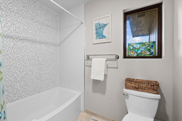 bathroom with baseboards, shower / bathtub combination with curtain, and toilet