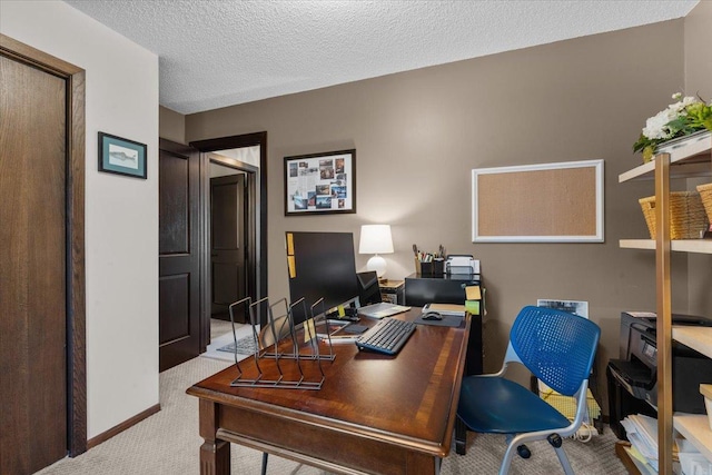 carpeted office featuring a textured ceiling and baseboards