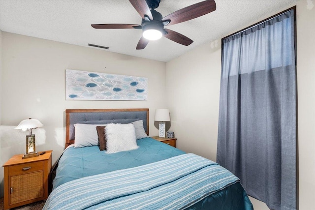 bedroom with ceiling fan, a textured ceiling, and visible vents