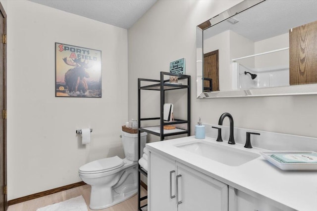 bathroom with a textured ceiling, toilet, wood finished floors, a shower, and vanity