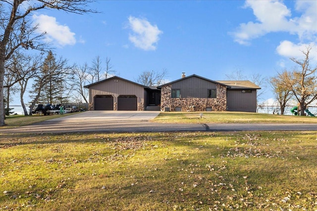 ranch-style house with stone siding, an attached garage, aphalt driveway, and a front yard