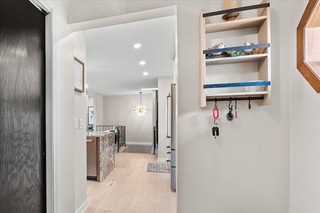 corridor with light wood-type flooring, baseboards, and recessed lighting