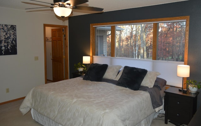 carpeted bedroom featuring baseboards and ceiling fan