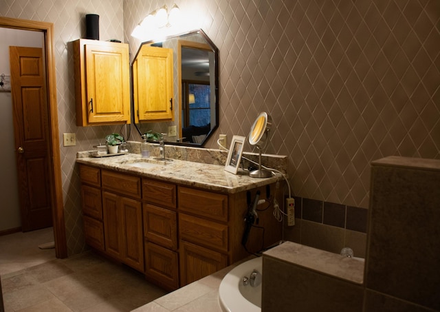 full bathroom with a bathing tub, tile walls, vanity, and tile patterned flooring