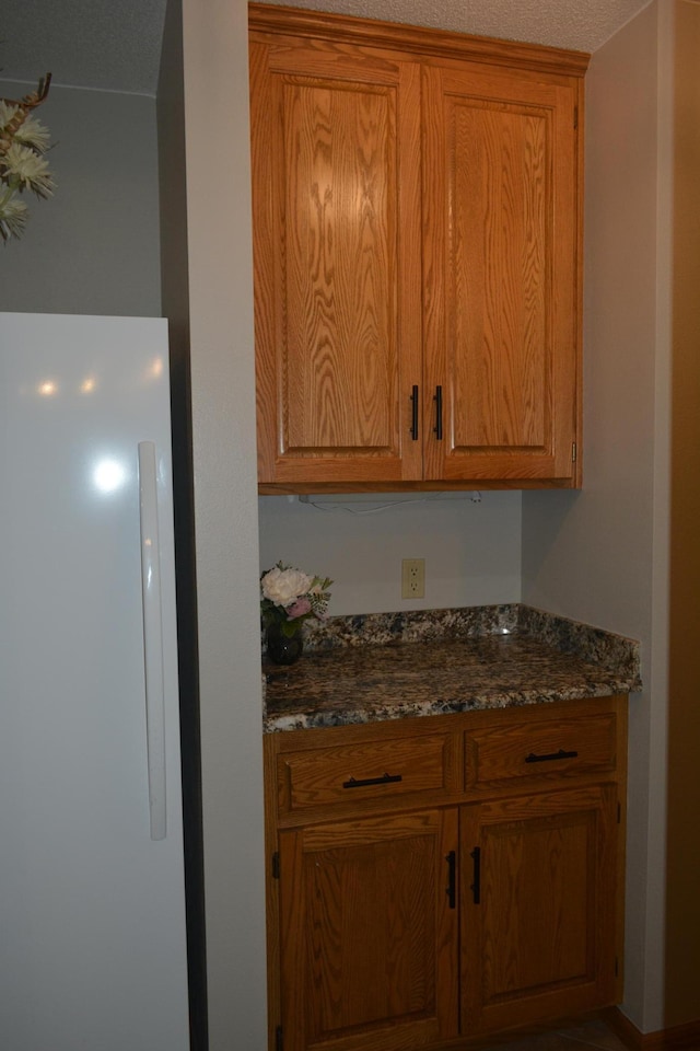 kitchen with dark stone countertops and brown cabinets