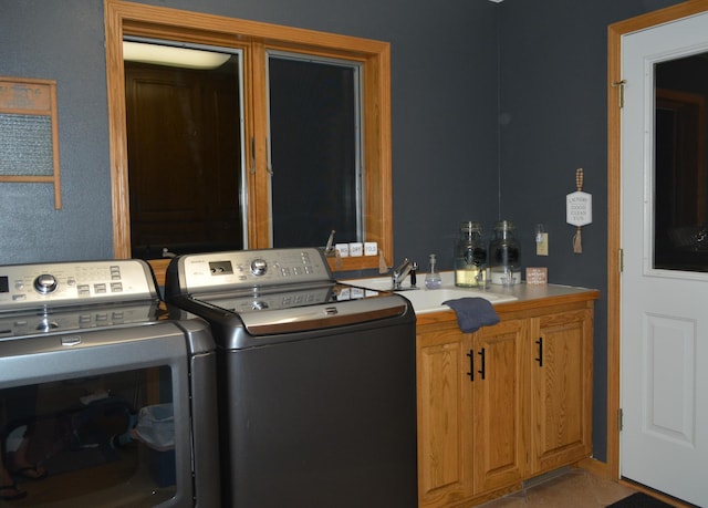 laundry area featuring cabinet space, independent washer and dryer, and a sink