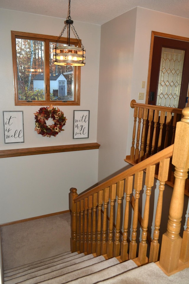 stairs featuring baseboards and carpet