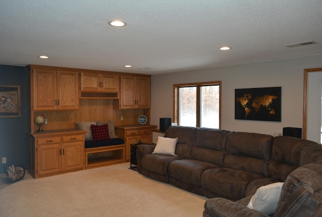 living room featuring a textured ceiling, recessed lighting, visible vents, and light carpet