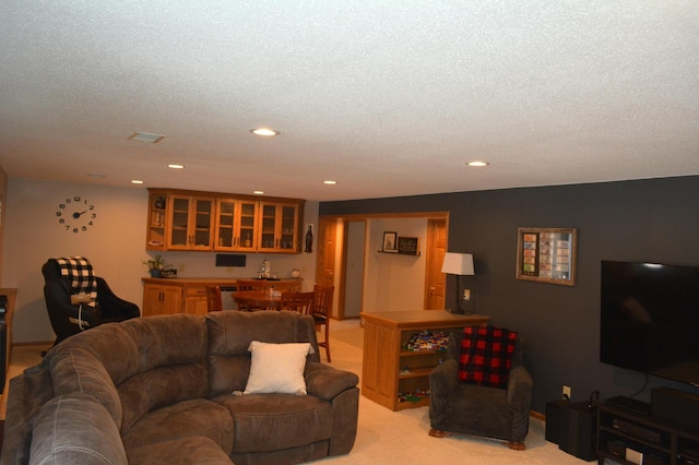 living room with recessed lighting, light colored carpet, and a textured ceiling