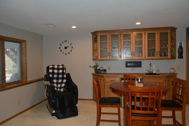 dining area featuring indoor wet bar, recessed lighting, light carpet, and baseboards