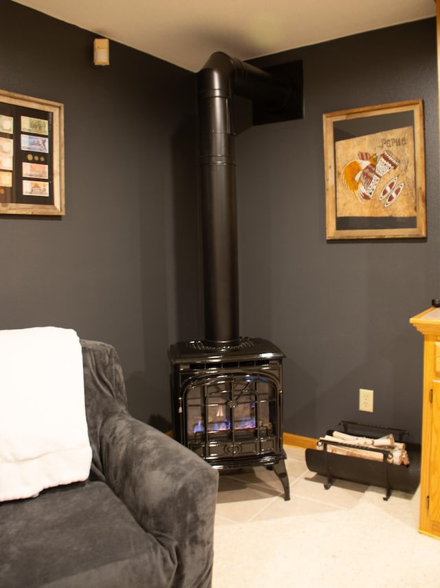 living area featuring baseboards and a wood stove