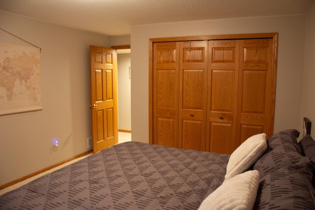 unfurnished bedroom featuring a closet, carpet flooring, a textured ceiling, and baseboards