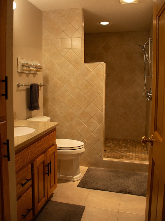 full bathroom with tile patterned flooring, vanity, toilet, and a walk in shower