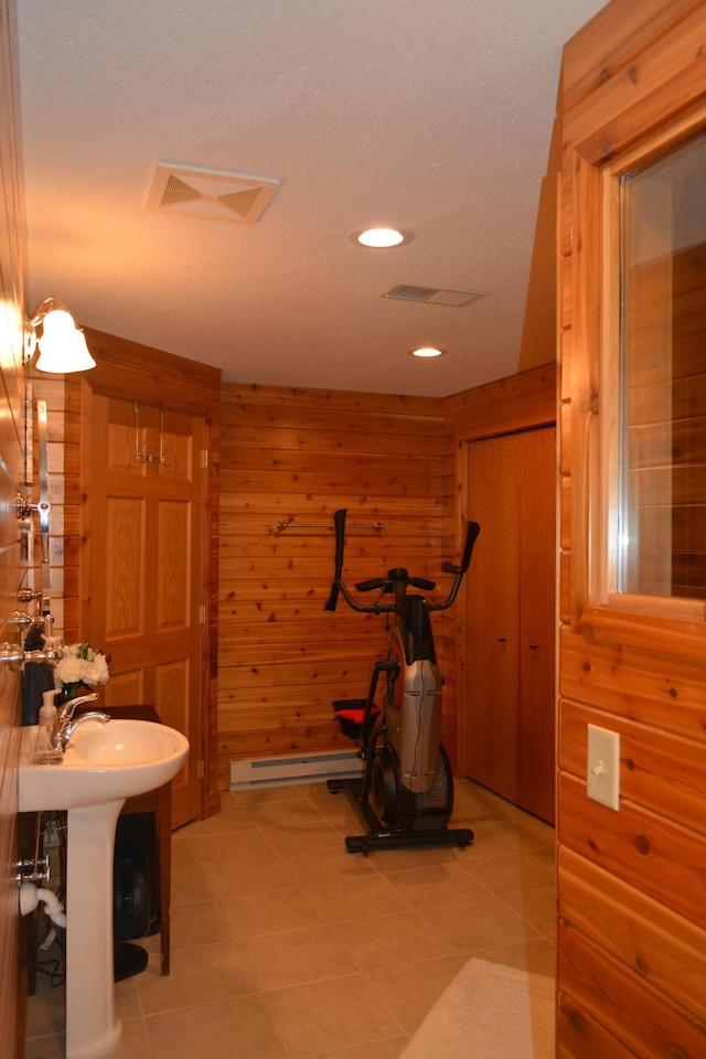 exercise area with recessed lighting, visible vents, wood walls, and a sink