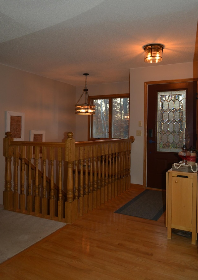 foyer with baseboards, a notable chandelier, and wood finished floors