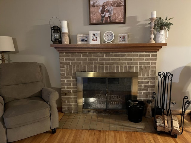 interior details with a brick fireplace and wood-type flooring