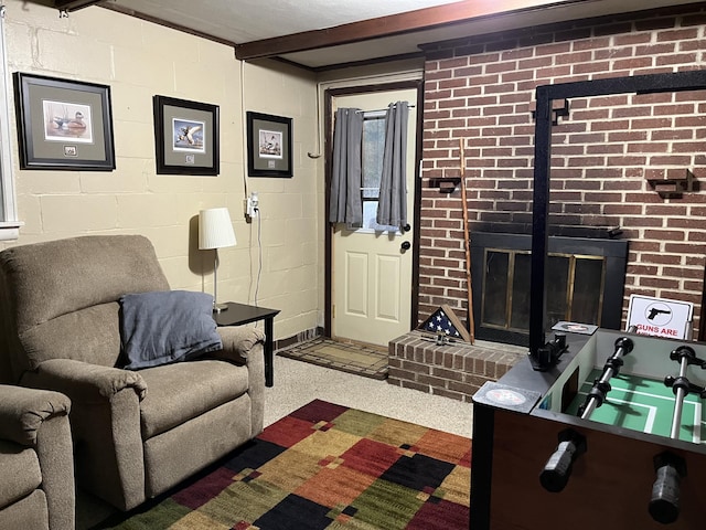 living room featuring beam ceiling and a brick fireplace