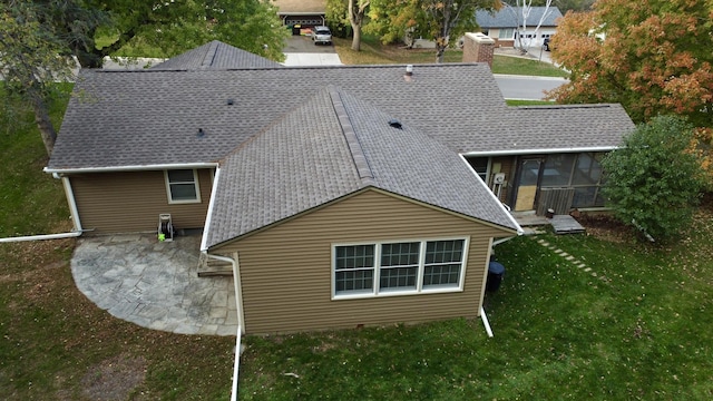 rear view of property with a yard and a sunroom