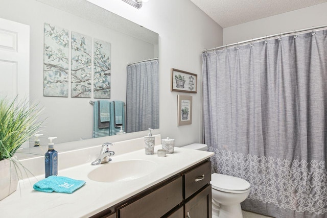 bathroom with vanity, toilet, and a textured ceiling