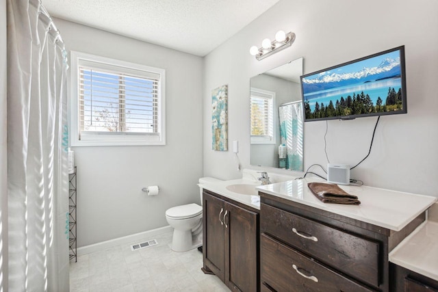 bathroom featuring vanity, a textured ceiling, and toilet