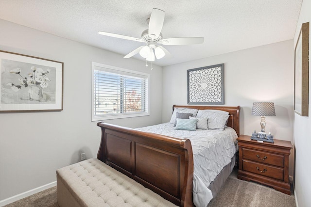 bedroom with ceiling fan, carpet flooring, and a textured ceiling