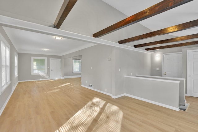 unfurnished room featuring beamed ceiling and light hardwood / wood-style floors