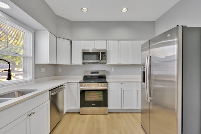 kitchen featuring sink, white cabinets, light hardwood / wood-style flooring, and stainless steel appliances