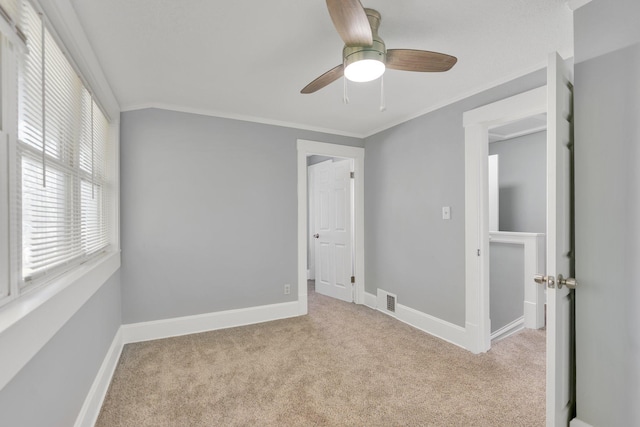 unfurnished bedroom featuring crown molding, light colored carpet, and ceiling fan