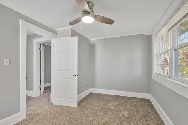 spare room with light carpet, ornamental molding, and ceiling fan