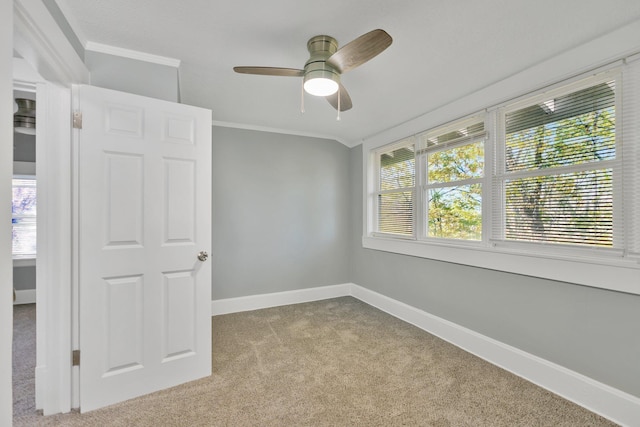 unfurnished room featuring crown molding, light colored carpet, and ceiling fan