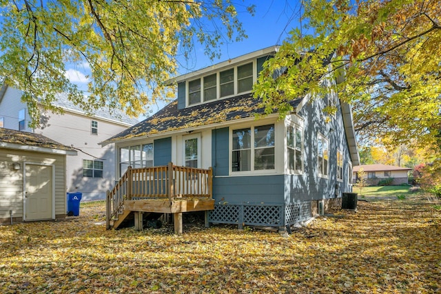 view of front facade with a wooden deck and a storage unit