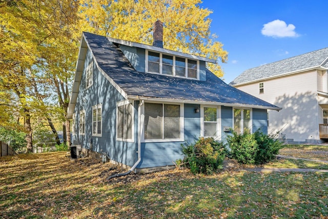 back of house featuring a sunroom and a lawn