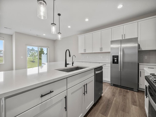 kitchen featuring stainless steel appliances, white cabinetry, and sink