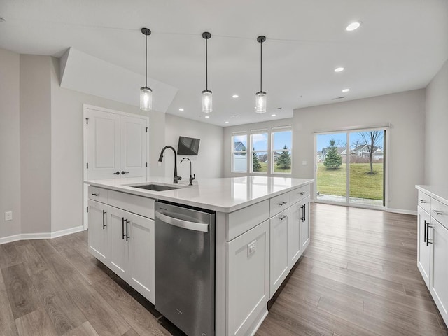 kitchen featuring stainless steel dishwasher, white cabinets, and sink